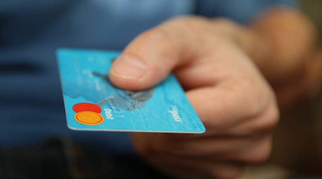 Person betaler med blåt kredit kort